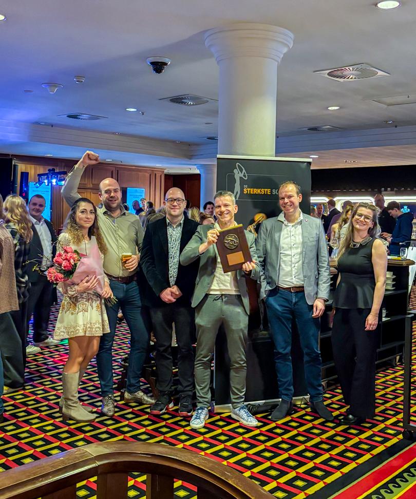 Groep PWA-medewerkers poseert op de uitreiking van de Sterkste Schakel en houdt trots de sectorprijs dienstverlening groot vast.