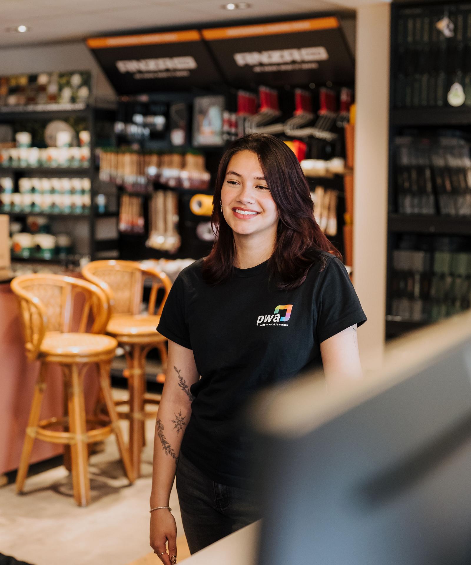 PWA-medewerker staat klaar om een klant te helpen aan de servicebalie.