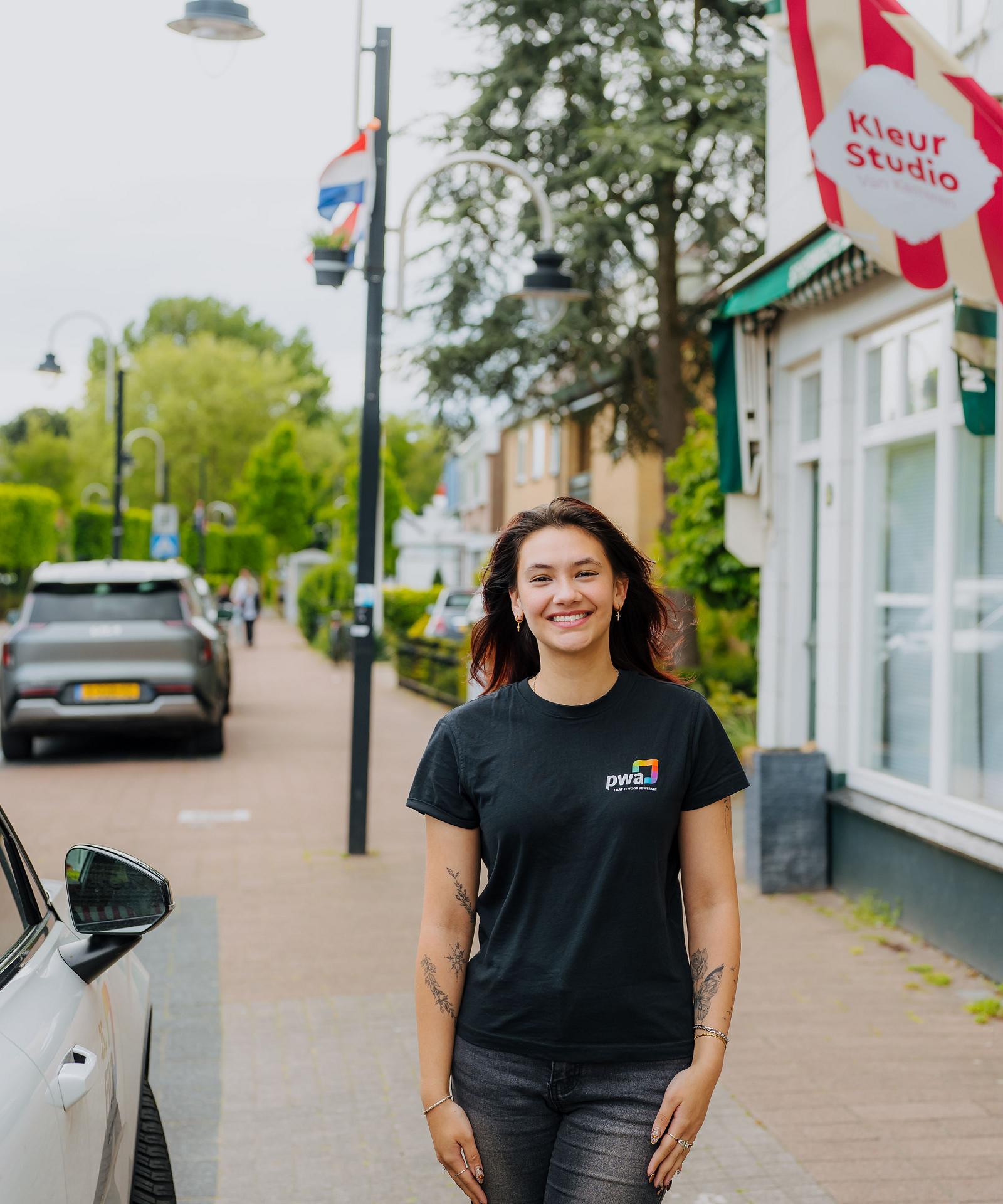 Vrouwelijke PWA-medewerker bezoekt klant op locatie voor persoonlijke IT-ondersteuning.