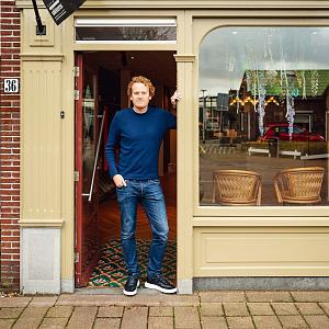 Medewerker van Van Kesteren Schilders staat in de deuropening van een verzorgd bedrijfspand.