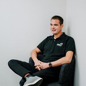 PWA-medewerker zit in een stoel op kantoor tijdens een gesprek over IT-dienstverlening.