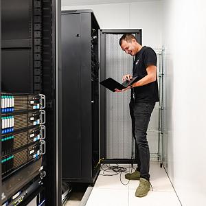 PWA-specialist voert beheerwerkzaamheden uit in een serverruimte met netwerkapparatuur.