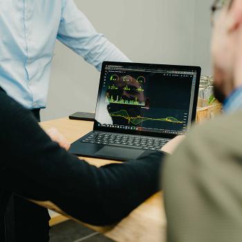 Medewerkers van PWA bekijken samen technische data op een laptop, tijdens een overlegmoment op kantoor.