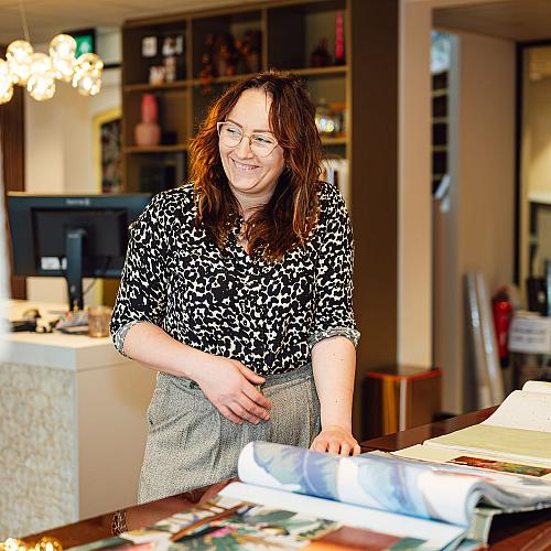 Medewerkster van Van Kesteren bekijkt kleur- en materiaalstalen aan een werktafel.