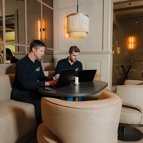 Twee PWA-specialisten werken samen aan een IT-project vanuit een moderne werkomgeving.