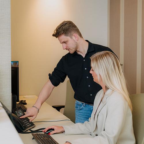 IT-consultant van PWA ondersteunt een klant bij het gebruik van een telefonieoplossing op kantoor.