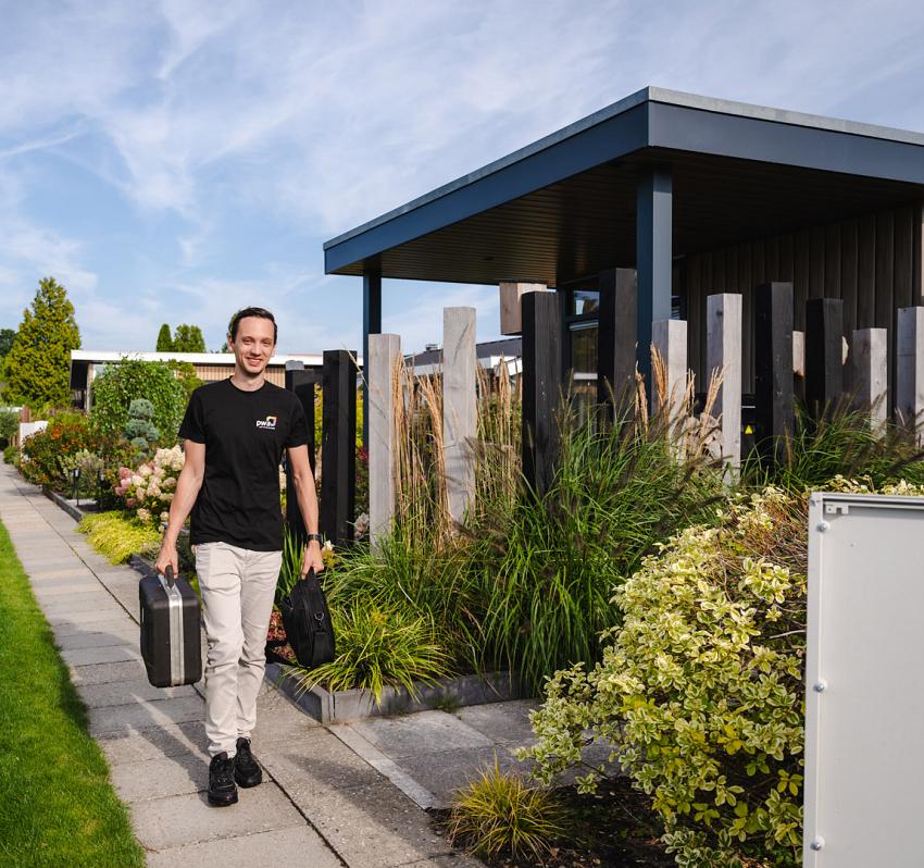 Twee collega's lopen lachend door een moderne kantoorruimte met kleurrijke kunst aan de muur en een laptop in de hand.